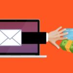 Estafa en linea, mano saliendo de la pantalla de una laptop para tomar dinero y una tarjeta bancaria