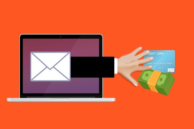 Estafa en linea, mano saliendo de la pantalla de una laptop para tomar dinero y una tarjeta bancaria