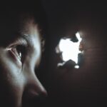 Persona observando a través de un orificio