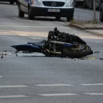 Motocicleta destrozada sobre una carretera después de un accidente.
