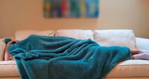 Una persona acostada en un sillón.