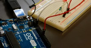 Fotografía de un arduino conectado a una protoboard sobre una mesa.