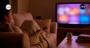 Mujer recostada en un sofa viendo la television.
